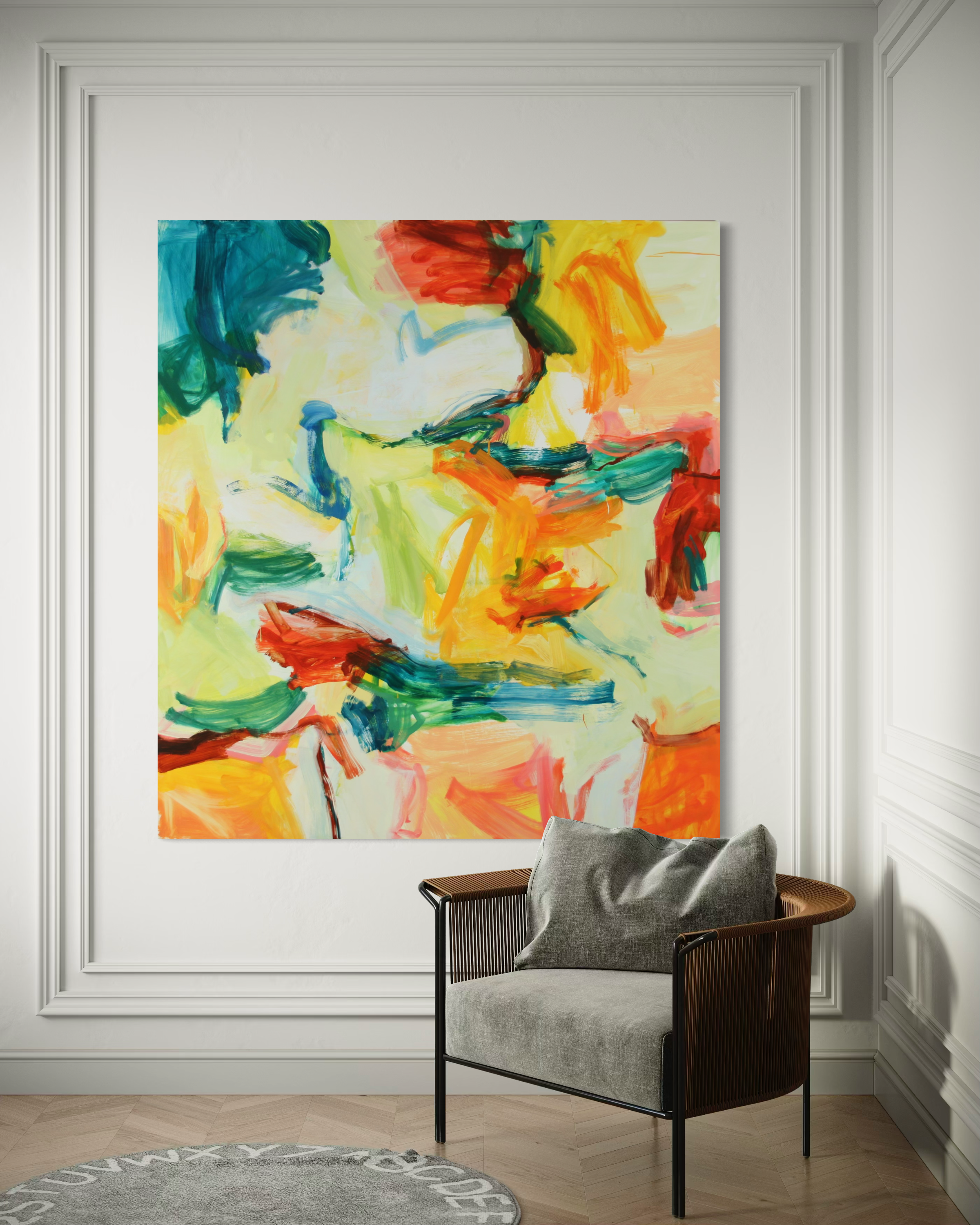 An abstract canvas painting with vibrant brushstrokes of yellow, orange, red, green, and blue, displayed on a white paneled wall above a modern gray armchair.
