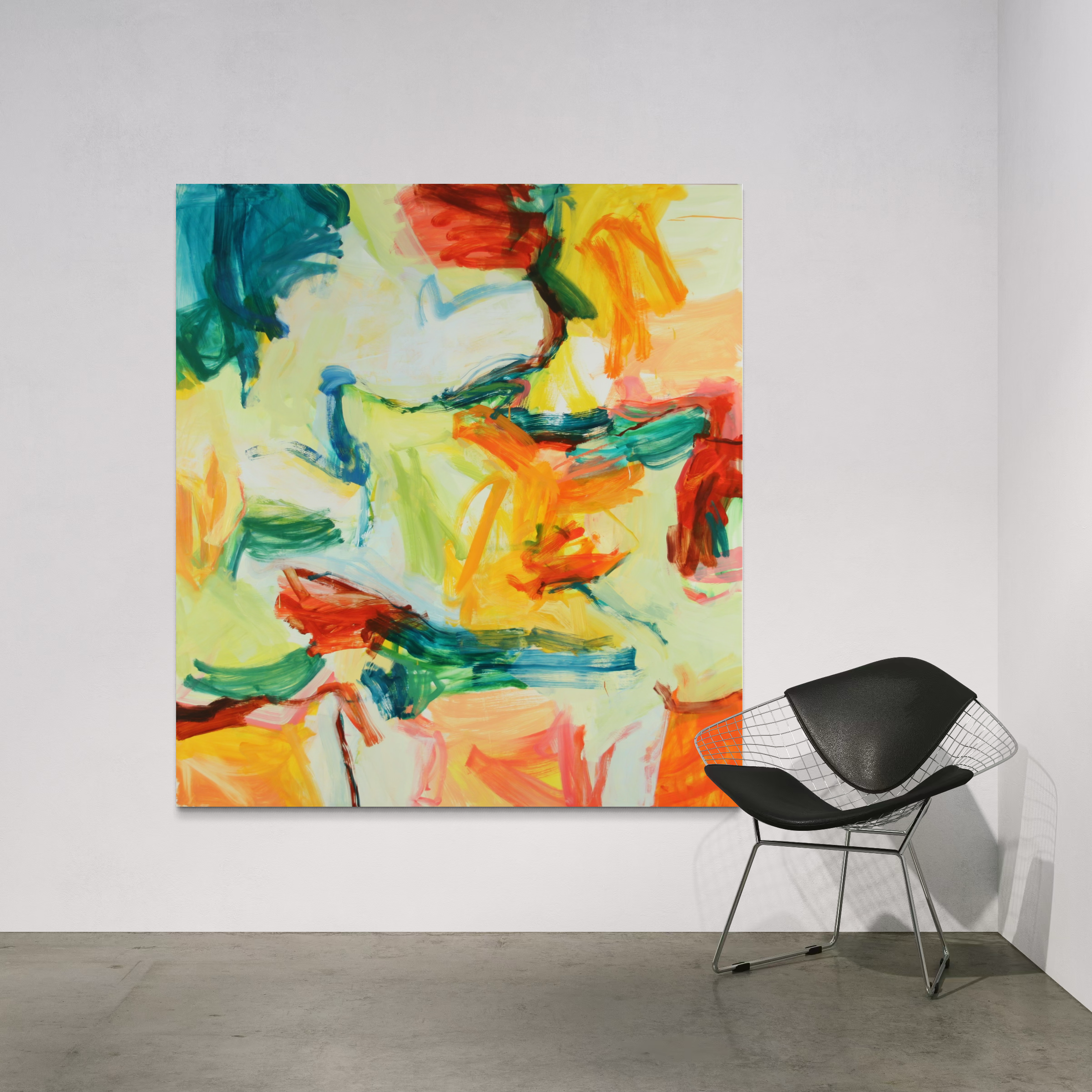 An abstract canvas painting with vibrant brushstrokes of yellow, orange, red, green, and blue, displayed on a white wall in a modern room setting next to a black wire chair.