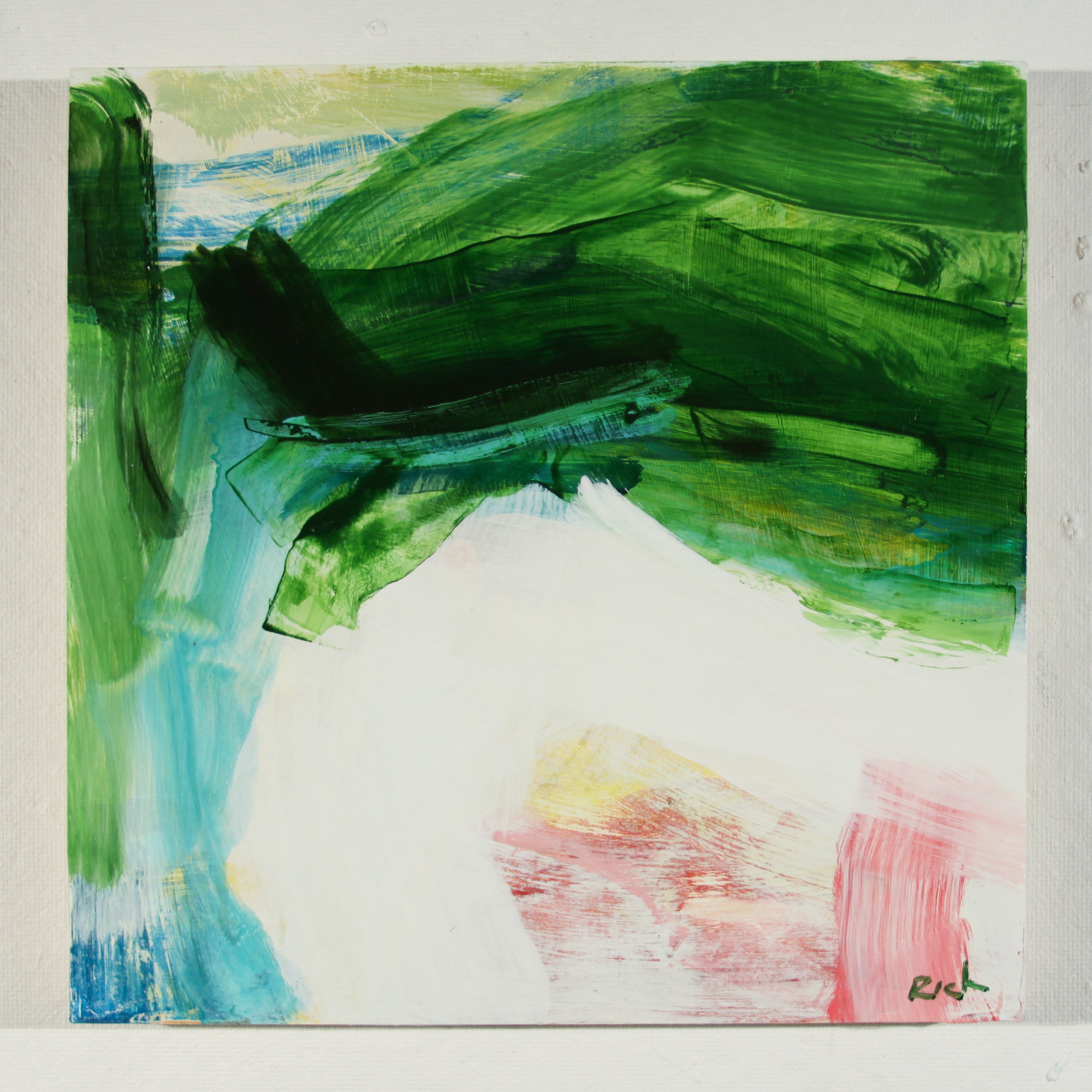 An abstract painting on a square canvas featuring bold green brushstrokes at the top, a large white central area, blue and green accents on the left, and pink and yellow accents in the lower right, with a small artist signature in the corner.