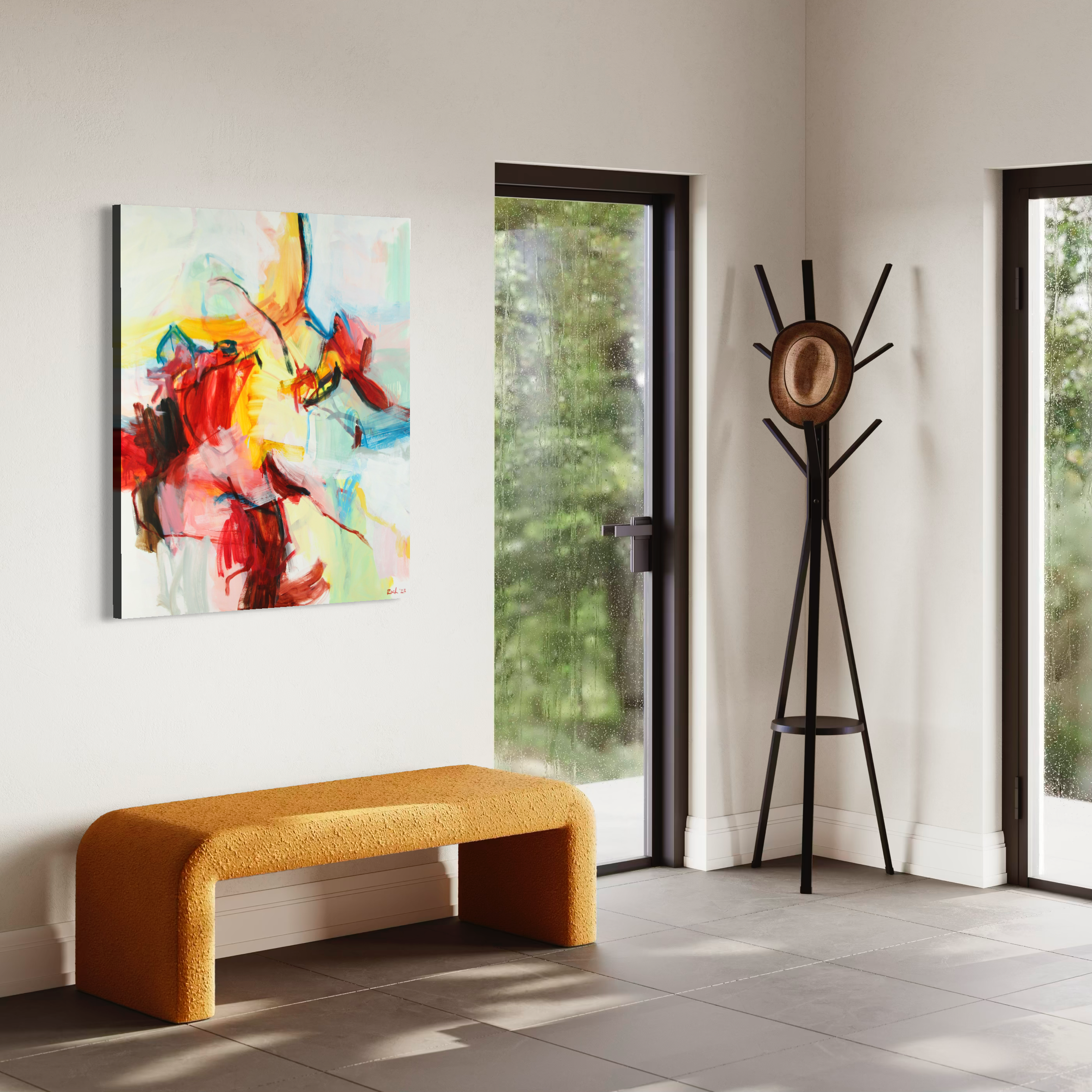 An abstract canvas painting with vibrant red, yellow, blue, and white brushstrokes hangs on a white wall in a modern entryway. Below the painting is a curved mustard-yellow upholstered bench, and to the right is a black metal coat rack with a hat on it.