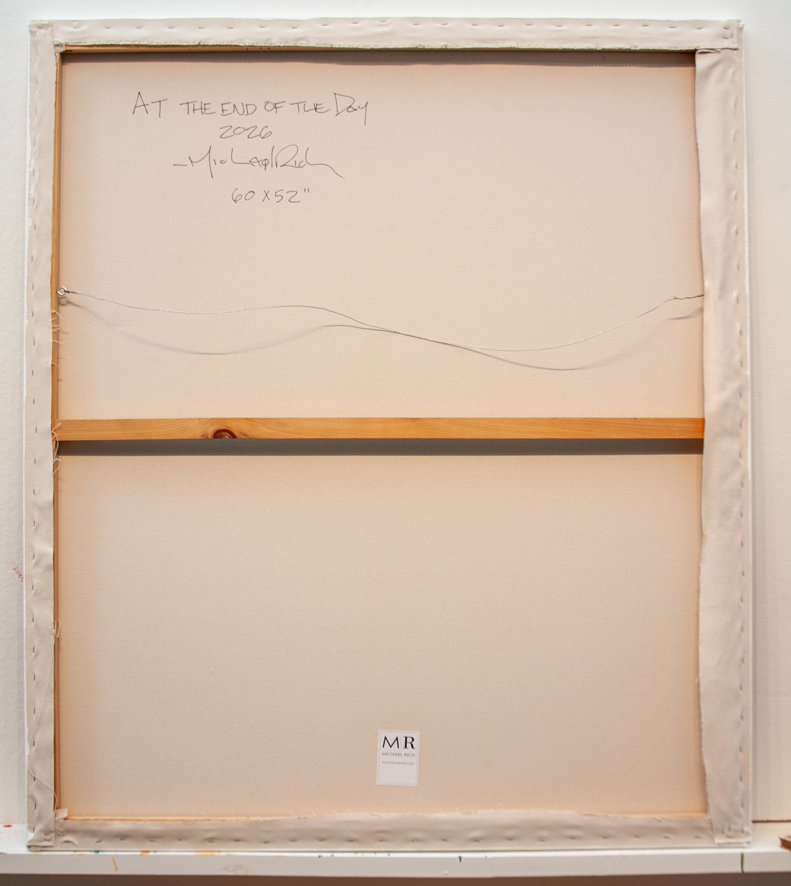 The back side of a canvas, showing the cream-colored fabric stretched over a wooden frame, with handwritten signature and dimensions at the top, and a small 'MR' label at the bottom.