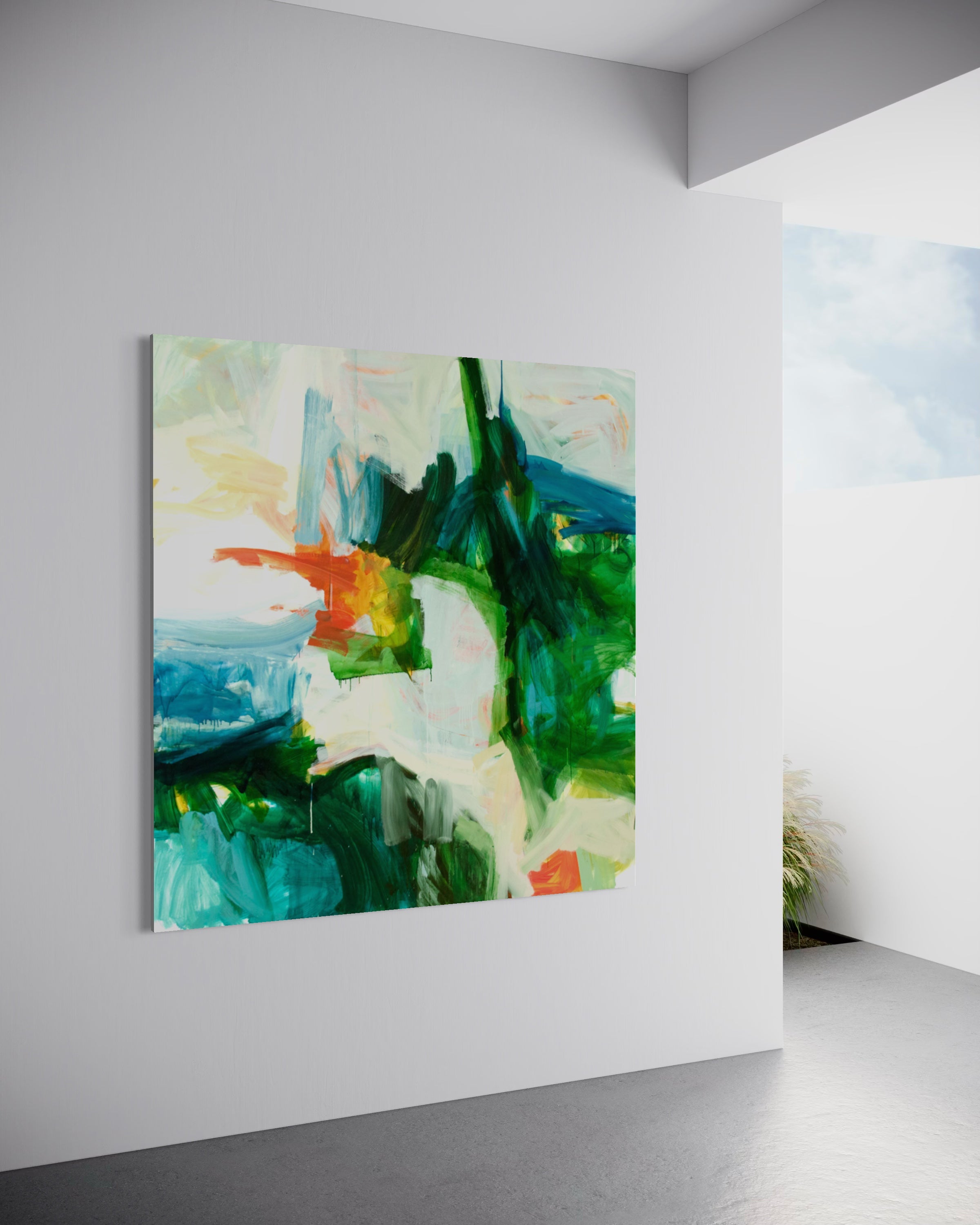 An abstract canvas painting with green, blue, white, and orange brushstrokes, displayed on a minimalist white gallery wall in a modern interior setting.