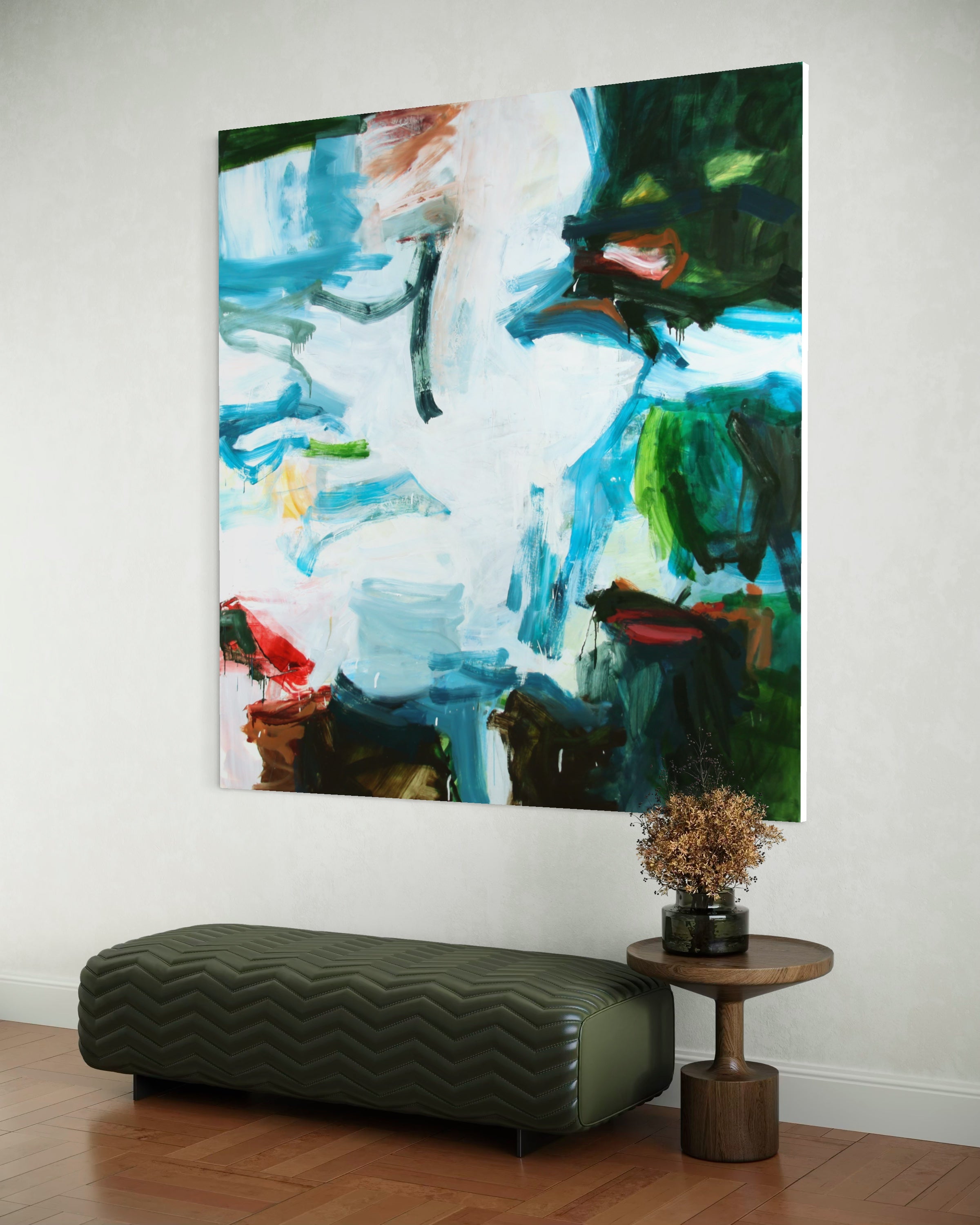 An abstract canvas painting with blue, green, white, and brown brushstrokes, displayed on a white wall above a dark green chevron-patterned bench and a small wooden side table with a vase of dried flowers.