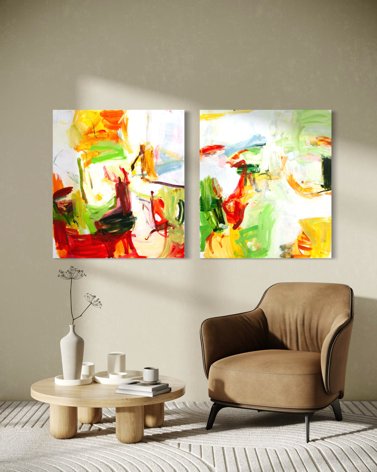 Two vertical abstract paintings by Michael Rich  wall art prints with vibrant red, yellow, green, and orange brushstrokes on a white background, displayed side-by-side on a beige wall above a brown armchair and a small wooden side table.