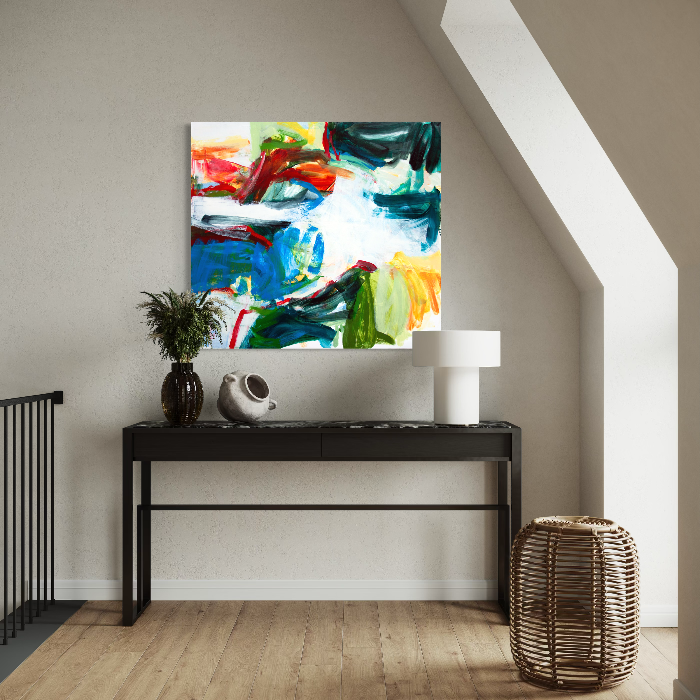 A square abstract canvas print with vibrant, expressive brushstrokes in blue, green, red, yellow, and white, displayed on a beige wall above a black console table in a modern room setting.