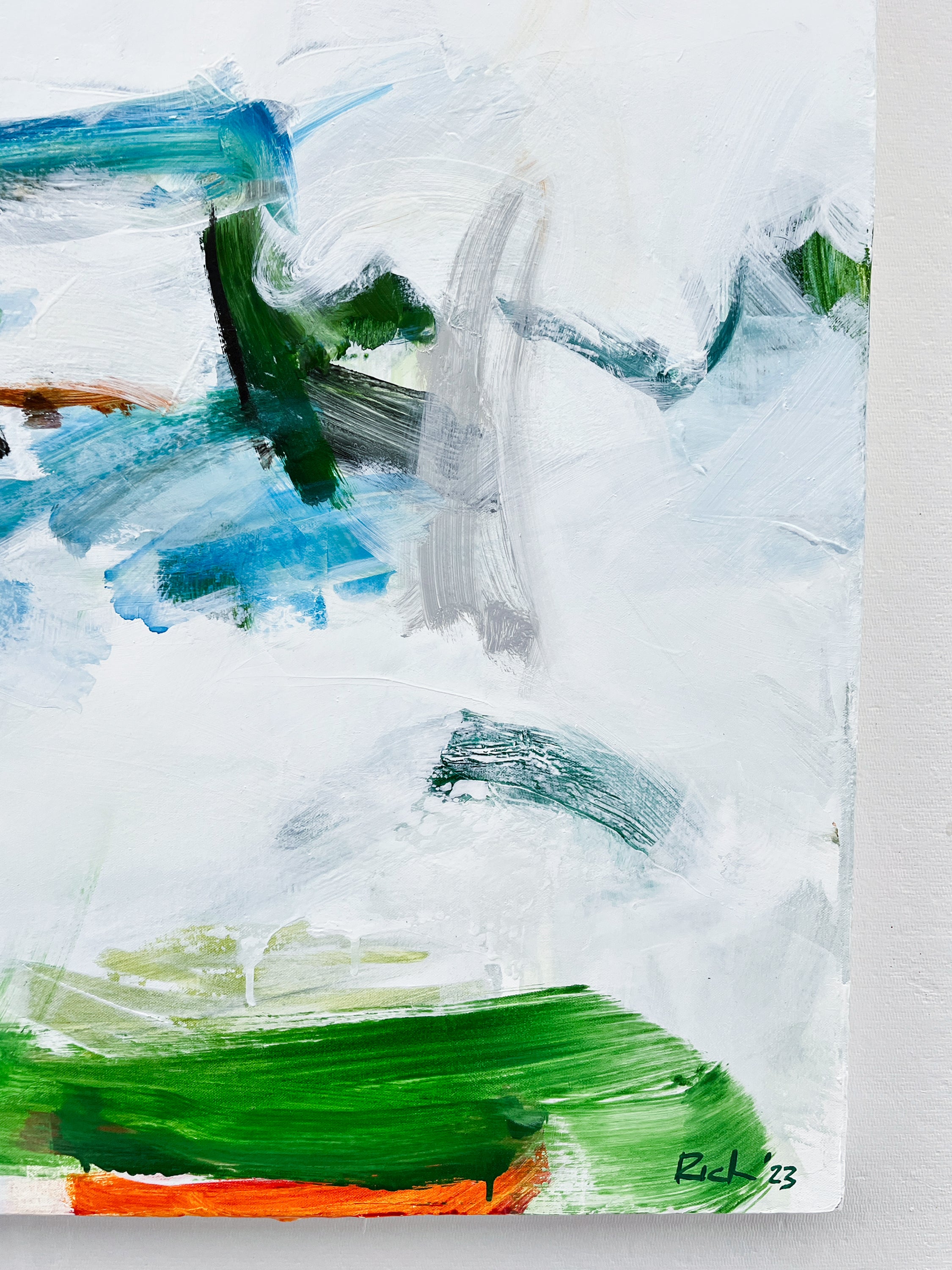 Abstract canvas painting with expressive brushstrokes in white, blue, green, gray, and a small orange accent, signed 'BK 23' in the lower right corner.